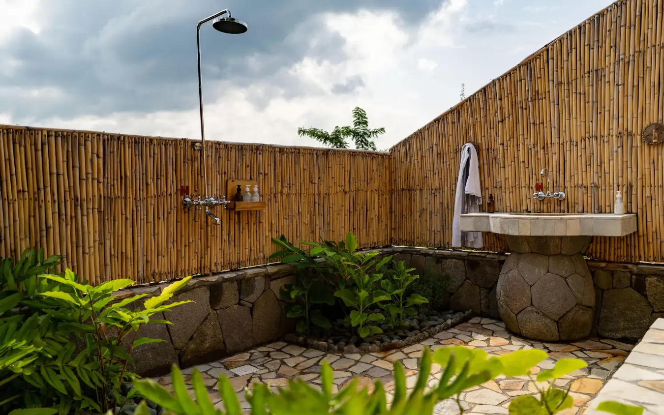 Outdoor bathroom with stone sink and bamboo privacy walls, Kibale Lodge, Kibale Forest, Uganda