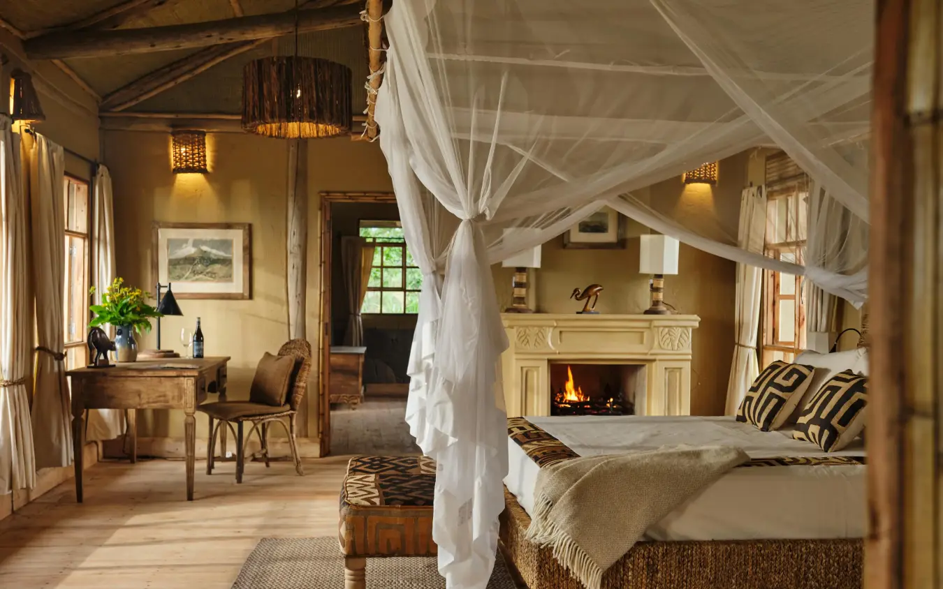 Spacious bedroom with fireplace and canopy bed, Kibale Lodge, Kibale Forest, Uganda