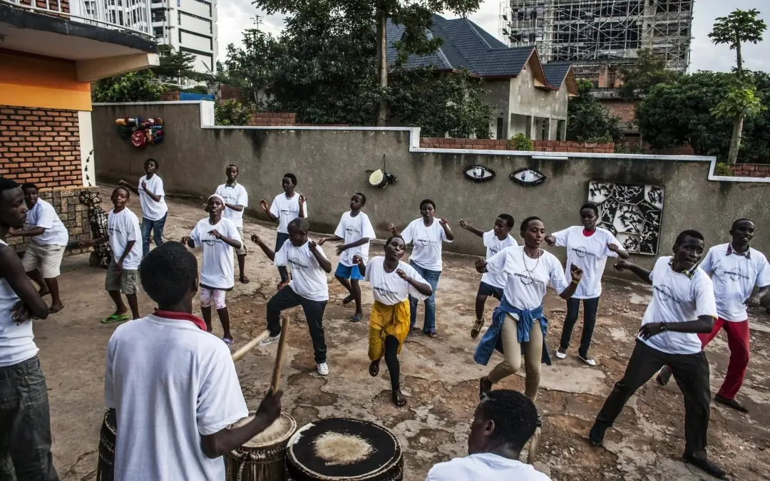 Group of people in white shirts dancing outdoors, Kigali Serena Hotel, Kigali, Rwanda