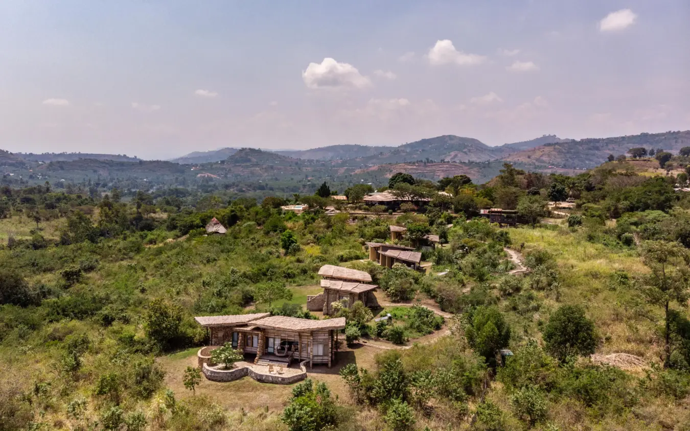 Scattered lodge buildings nestled among green hills and vegetation, Kyambura Gorge Lodge, Queen Elizabeth NP, Uganda