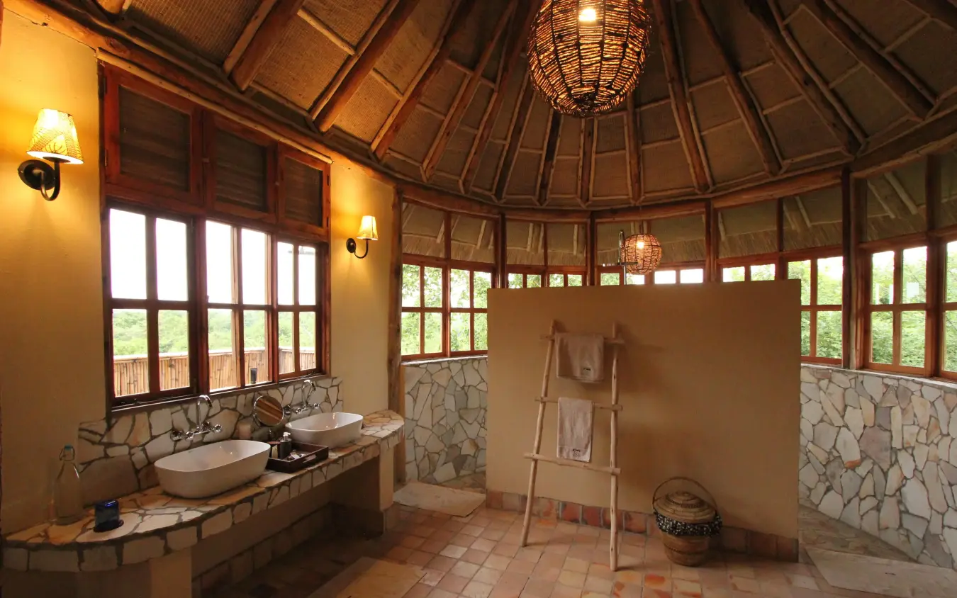 Octagonal bathroom with dual vessel sinks and stone accents, Kyambura Gorge Lodge, Queen Elizabeth NP, Uganda