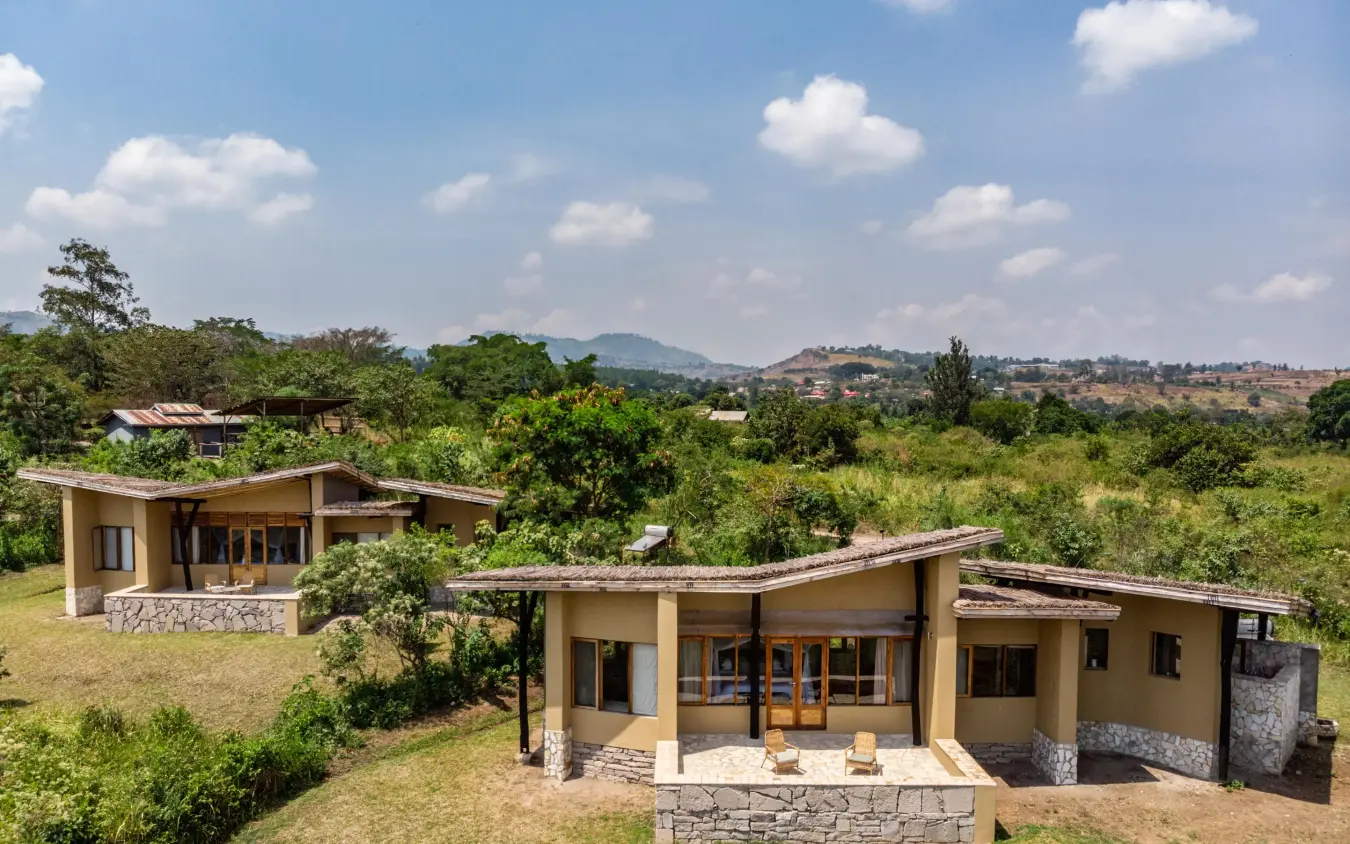 Modern lodge buildings nestled in lush green landscape with mountains, Kyambura Gorge Lodge, Queen Elizabeth NP, Uganda