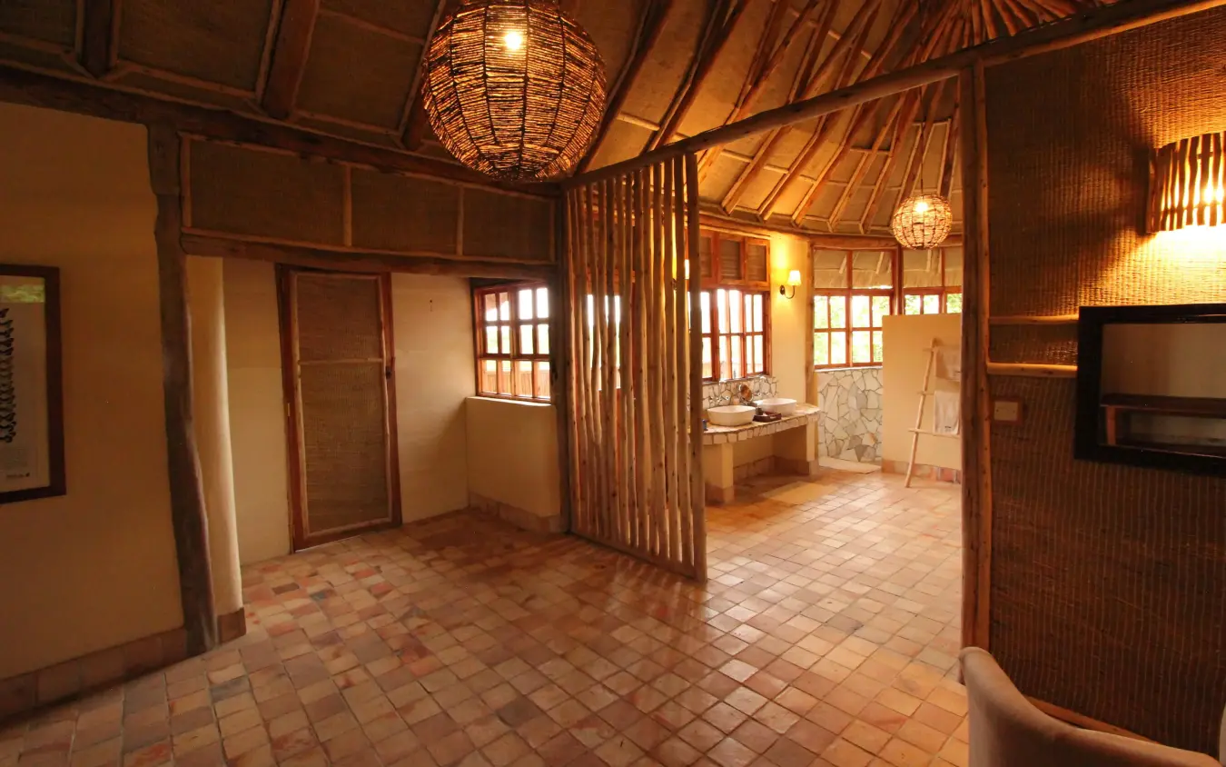 Interior lounge with wooden beams and warm lighting, Kyambura Gorge Lodge, Queen Elizabeth NP, Uganda