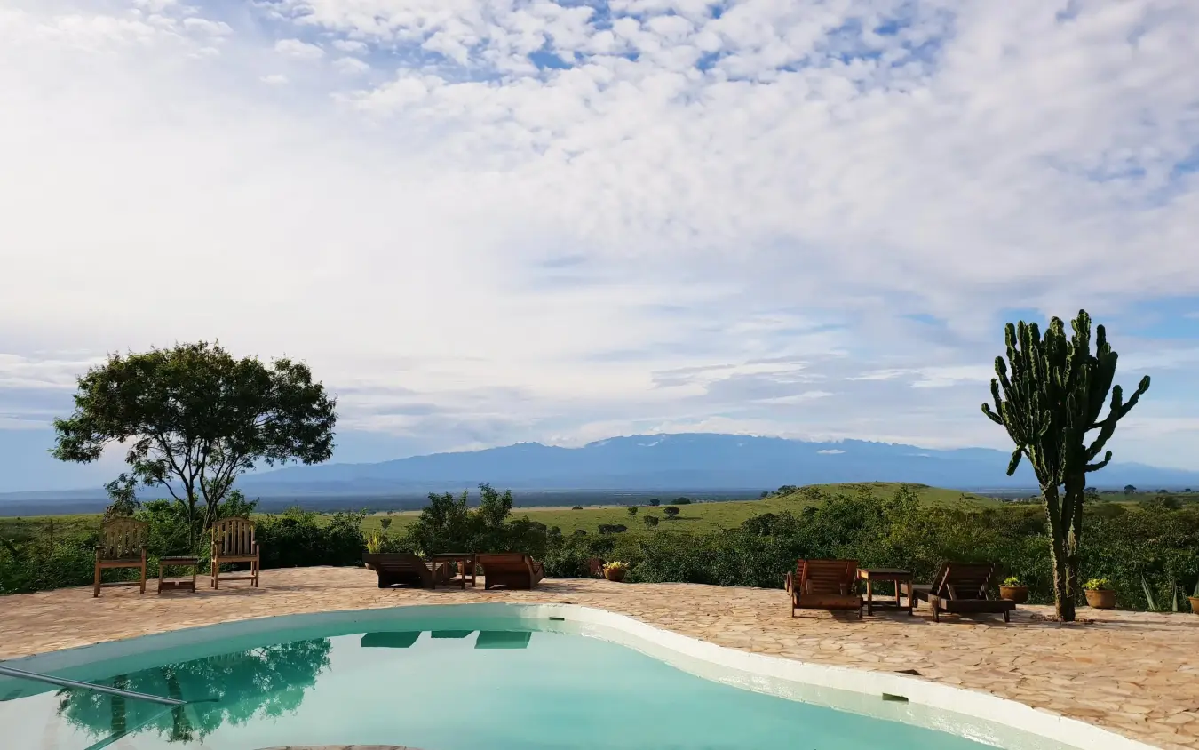Infinity pool overlooking savanna and distant mountains, Kyambura Gorge Lodge, Queen Elizabeth NP, Uganda