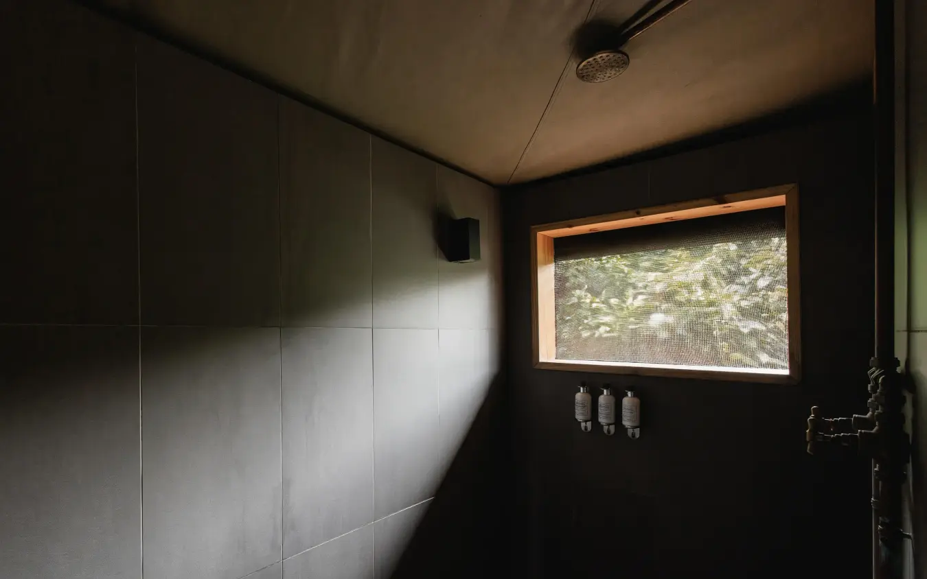 Modern bathroom interior with window overlooking natural landscape, Magashi Camp, Akagera National Park, Rwanda