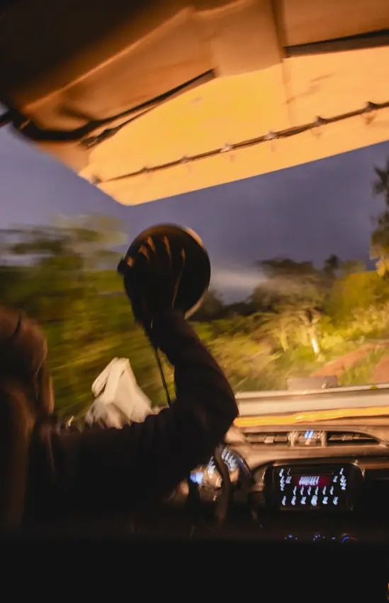Guests on open vehicle game drive at dusk with landscape, Akagera National Park, Rwanda