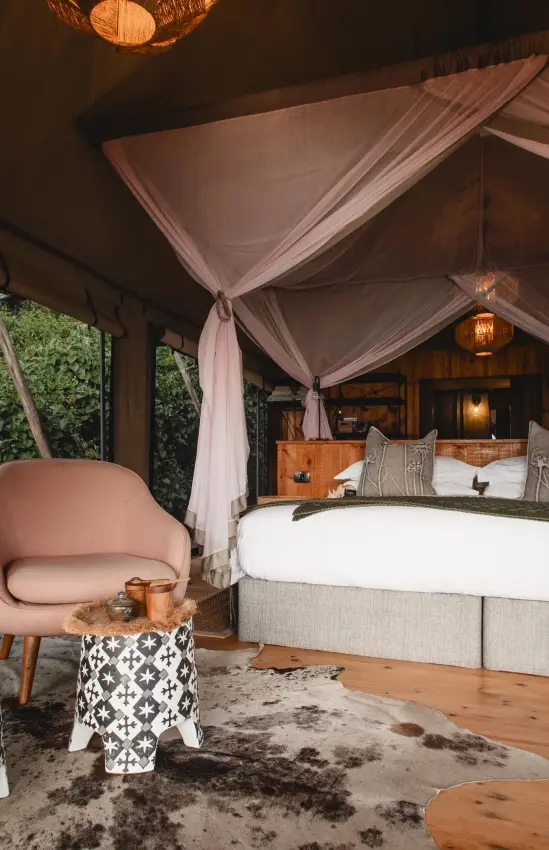 Luxury safari tent bedroom with canopy bed and seating area, Magashi Camp, Akagera National Park, Rwanda