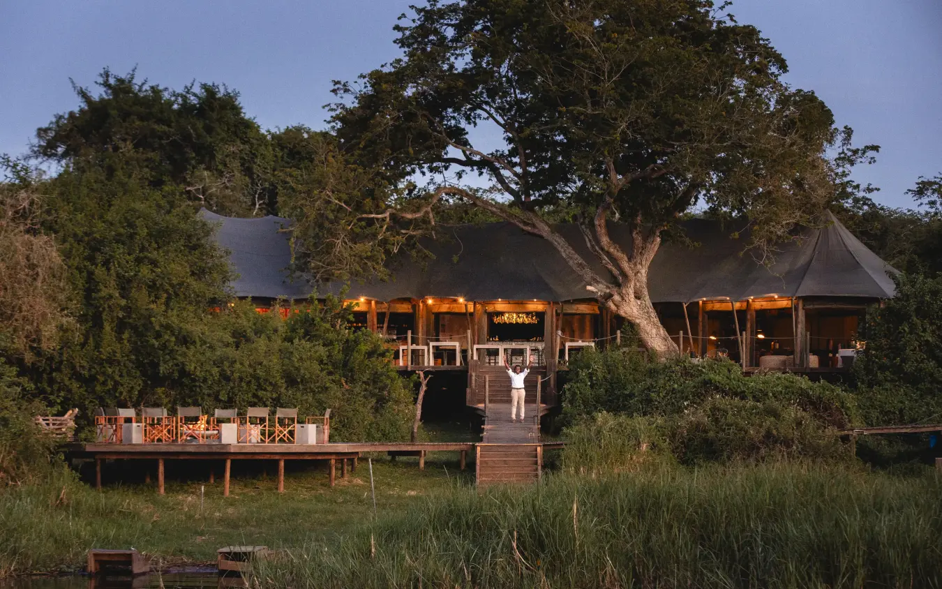 Waterfront lodge with canvas tents lit at dusk, Magashi Camp, Akagera National Park, Rwanda