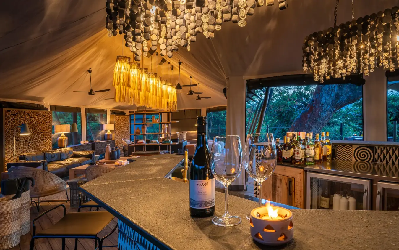 Evening interior lounge with wine service and ambient lighting, Magashi Camp, Akagera National Park, Rwanda