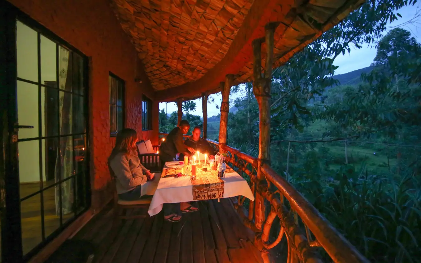 Evening dinner setup on covered wooden deck overlooking valley, Mahogany Springs, Bwindi Impenetrable Forest, Uganda
