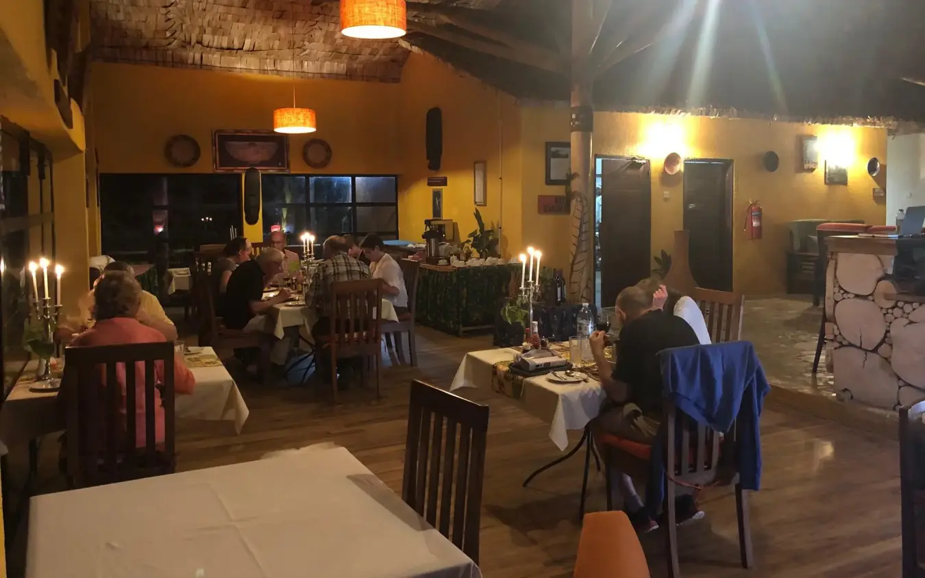 Evening dining room with guests seated at tables, Mahogany Springs, Bwindi Impenetrable Forest, Uganda