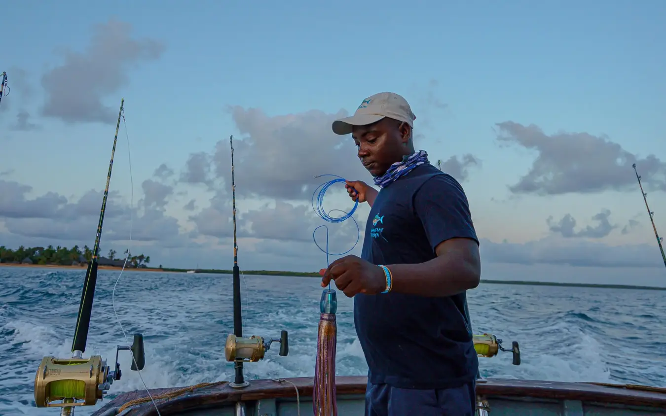 Fisherman holding net on boat at sunset, Manda Bay, Lamu Archipelago, Kenya