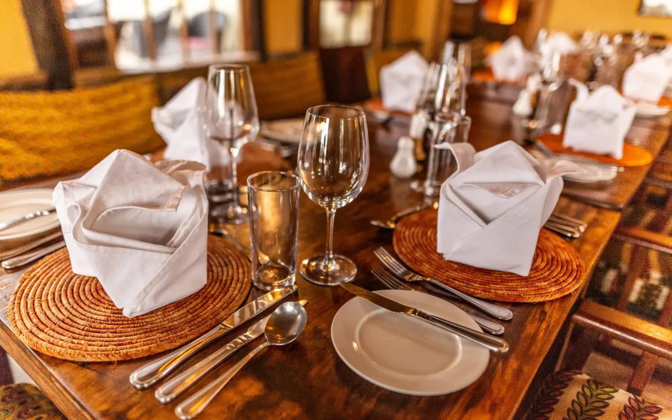 Fine dining table setting with formal place settings and glassware, Mount Gahinga Lodge, Mgahinga National Park, Uganda