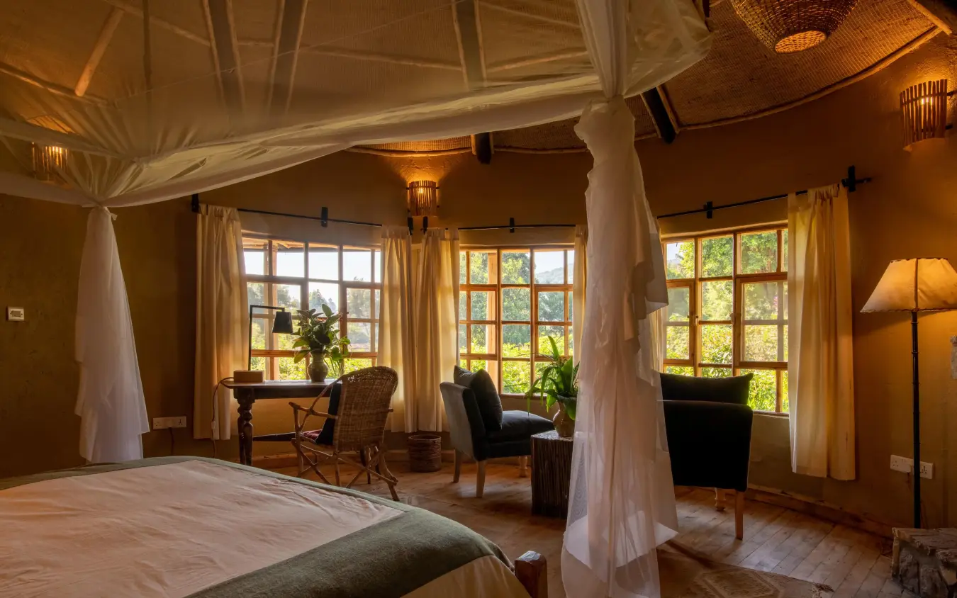 Luxurious bedroom with canopy bed and large windows, Mount Gahinga Lodge, Mgahinga National Park, Uganda