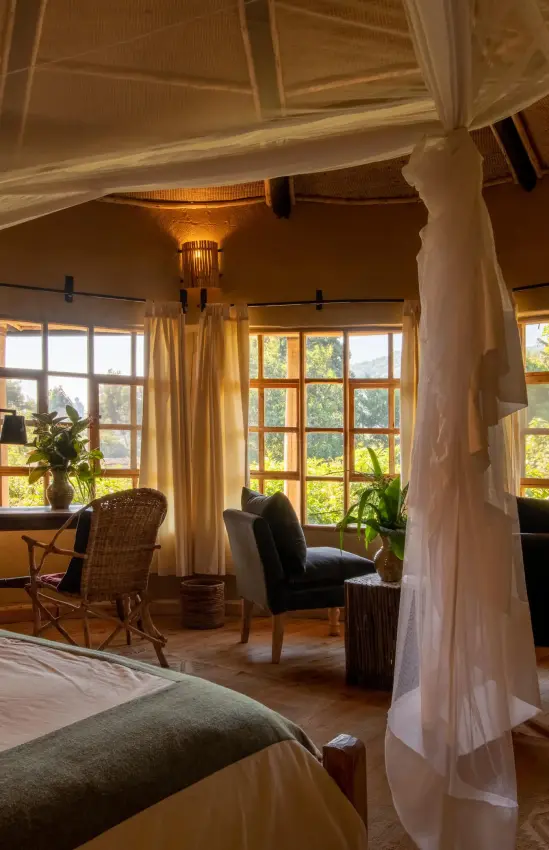 Luxurious bedroom with canopy bed and large windows, Mount Gahinga Lodge, Mgahinga National Park, Uganda