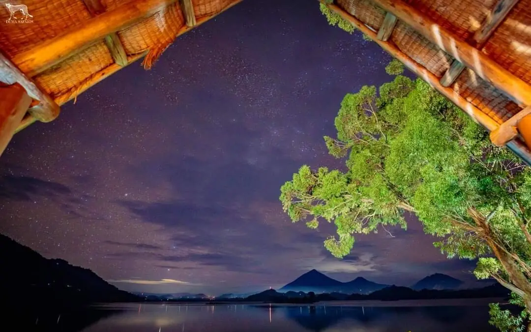 Starlit night sky over calm lake with mountain silhouettes, Mutanda Lake Resort, Lake Mutanda, Uganda