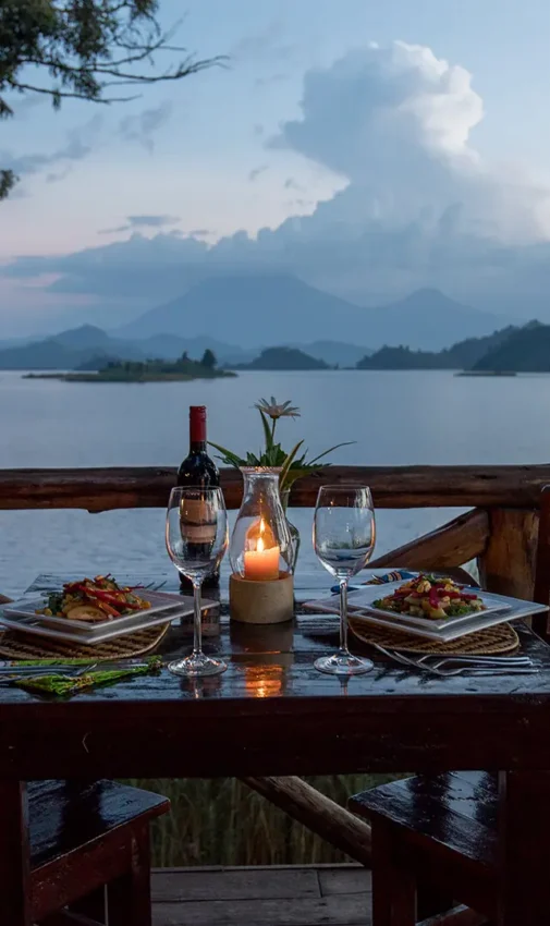 Lakeside dining setup on wooden deck at sunset, Mutanda Lake Resort, Lake Mutanda, Uganda