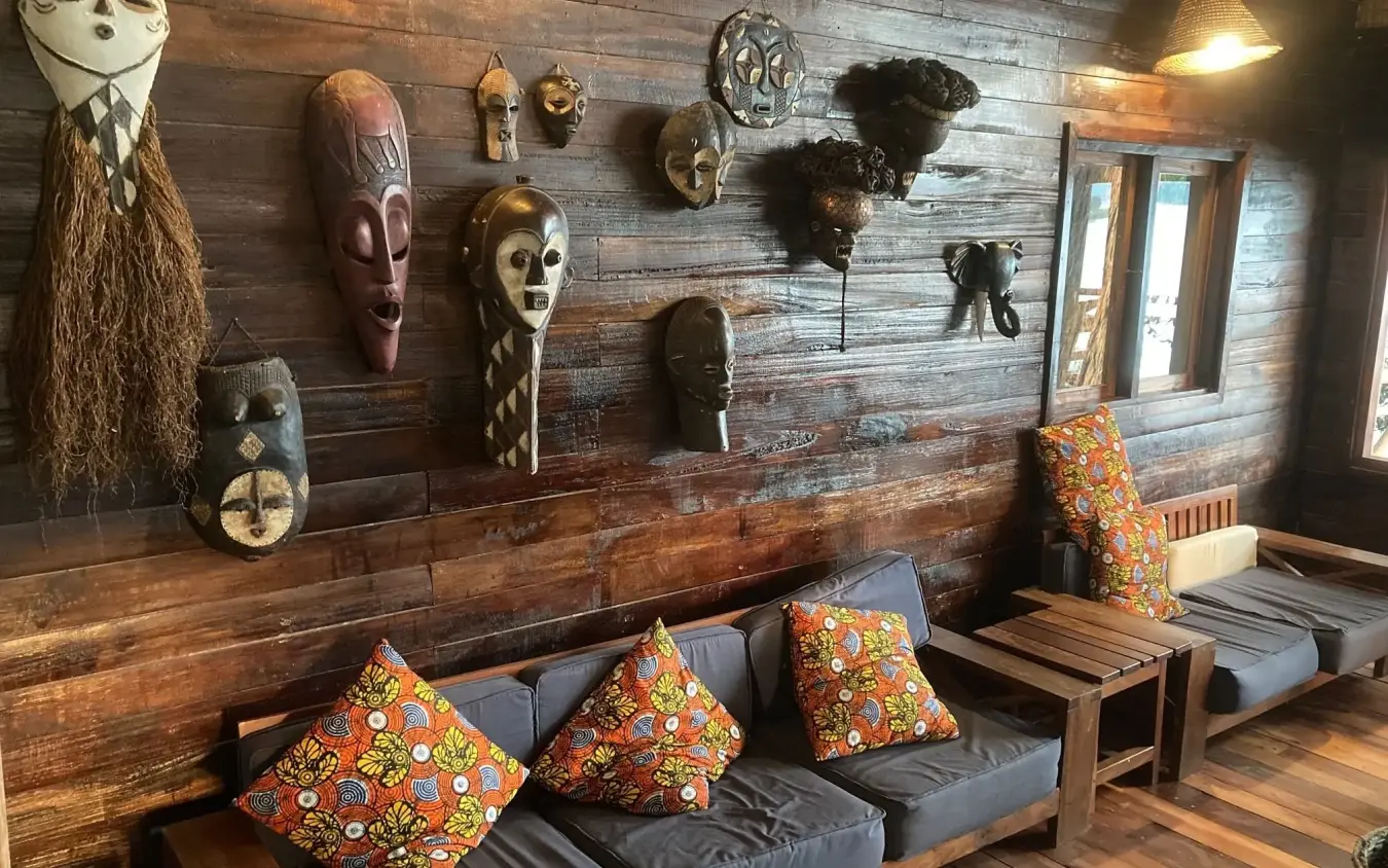 Interior lounge with African masks and colorful cushions, Mutanda Lake Resort, Lake Mutanda, Uganda