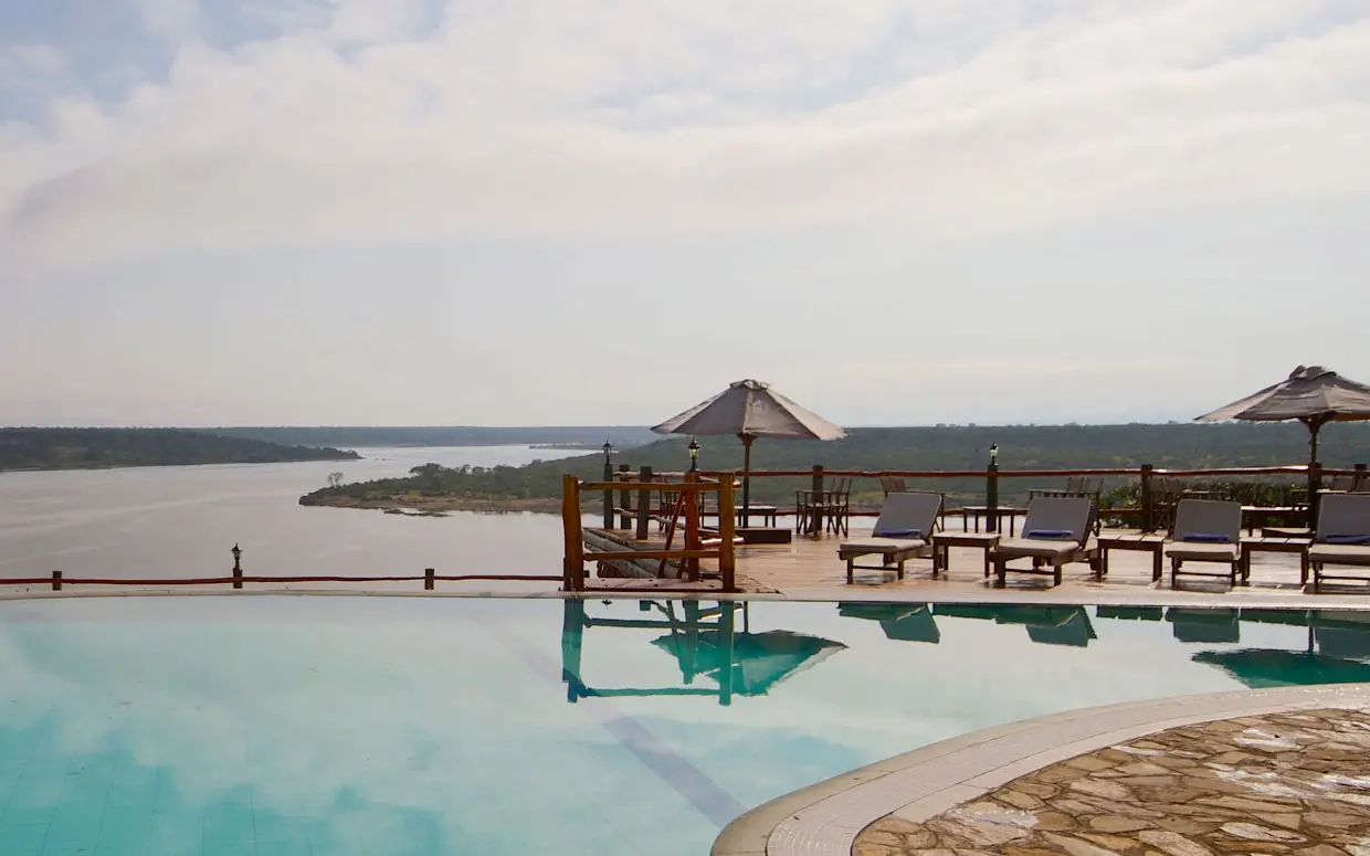 Infinity pool overlooking river with lounge chairs and gazebos, Mweya Safari Lodge, Queen Elizabeth NP, Uganda