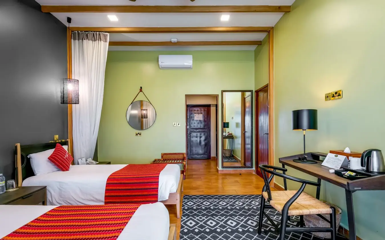 Twin bed guest room with lime green walls and red accents, Mweya Safari Lodge, Queen Elizabeth NP, Uganda