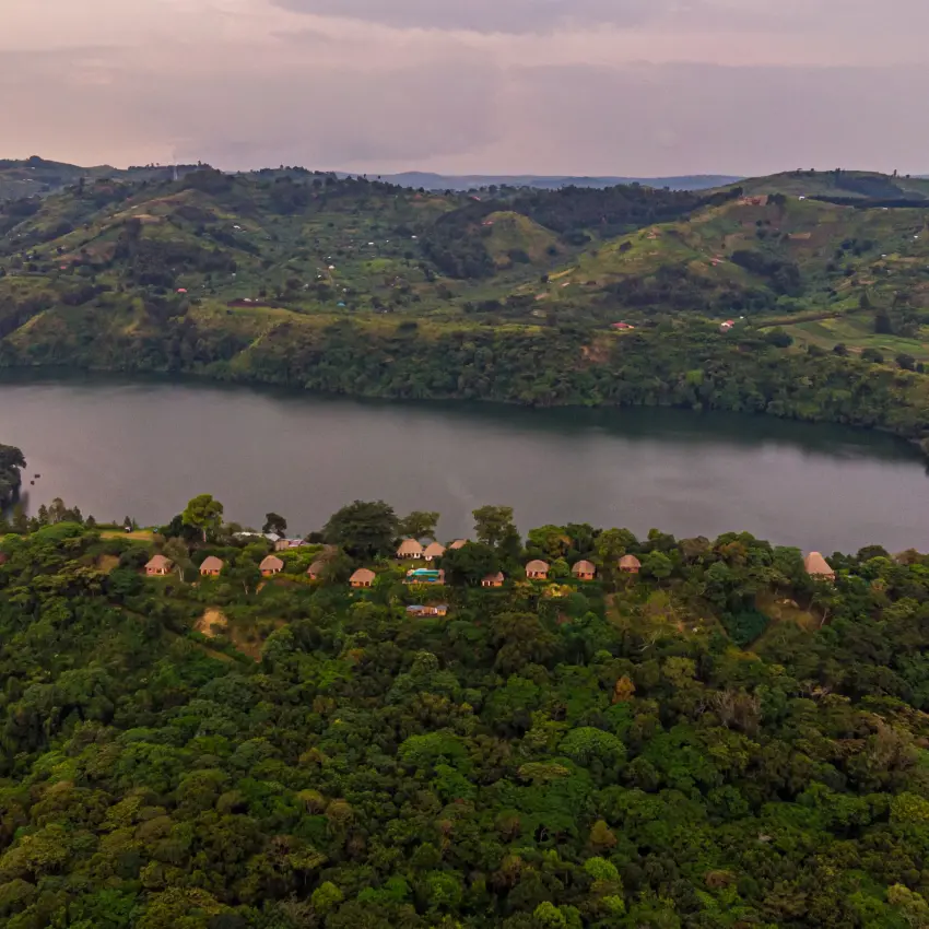 Aerial view of lake surrounded by forested hills and scattered structures, Ndali Lodge, Kibale Forest, Uganda