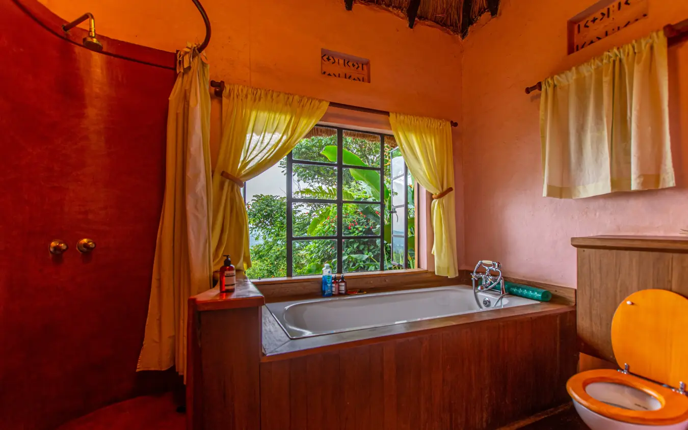 Colorful bathroom with wooden bathtub and large window, Ndali Lodge, Kibale Forest, Uganda