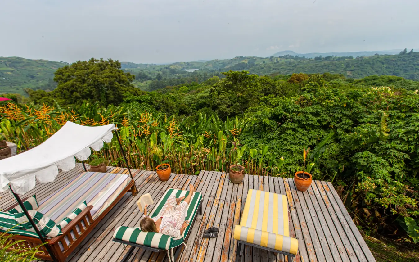 Wooden deck with loungers overlooking lush green valley, Ndali Lodge, Kibale Forest, Uganda
