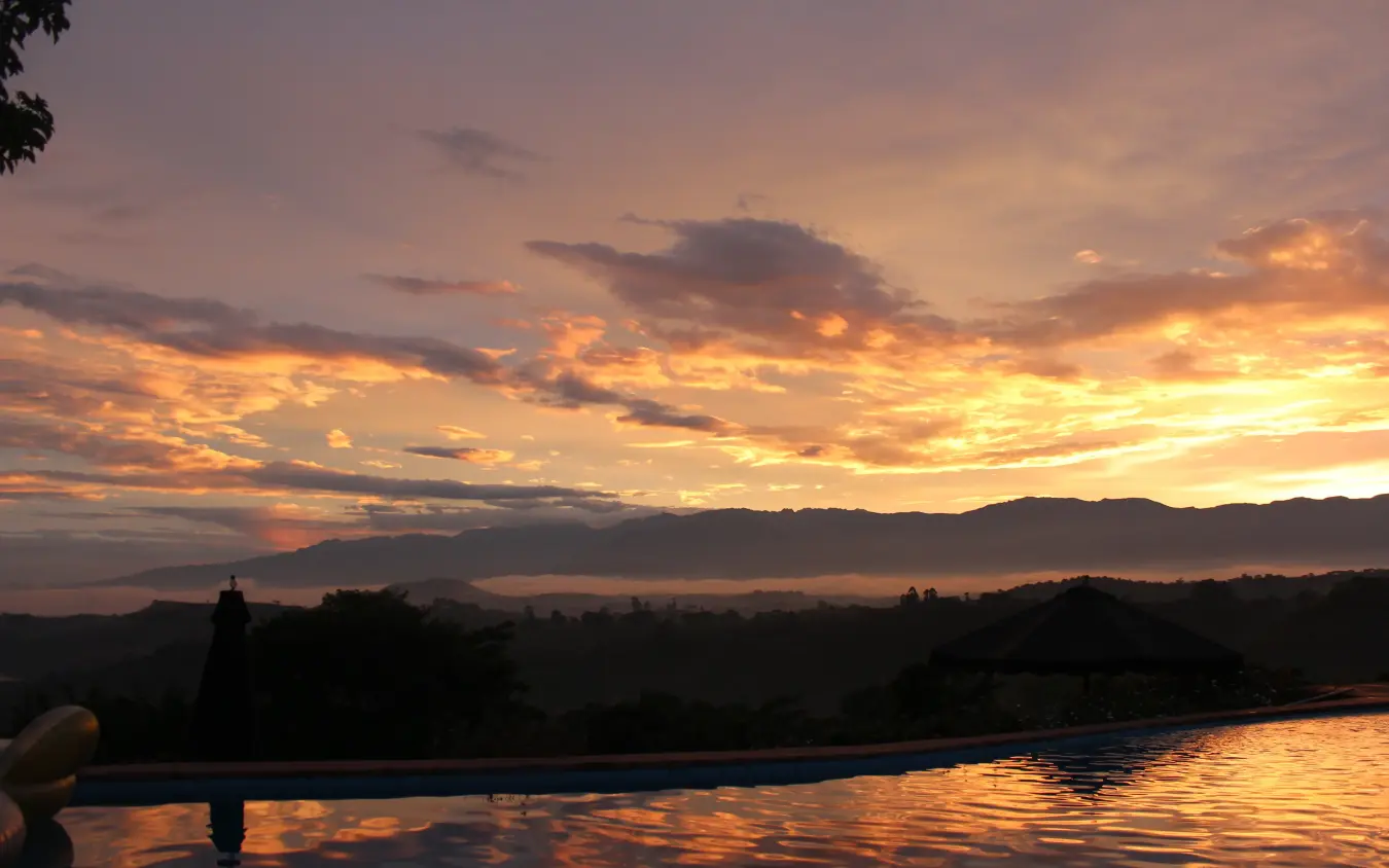 Infinity pool overlooking valley at sunset with mountains, Ndali Lodge, Kibale Forest, Uganda