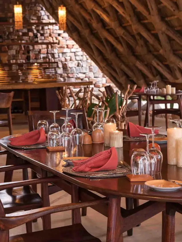 Elegant dining table set with red napkins and glassware, Nile Safari Lodge, Murchison Falls NP, Uganda