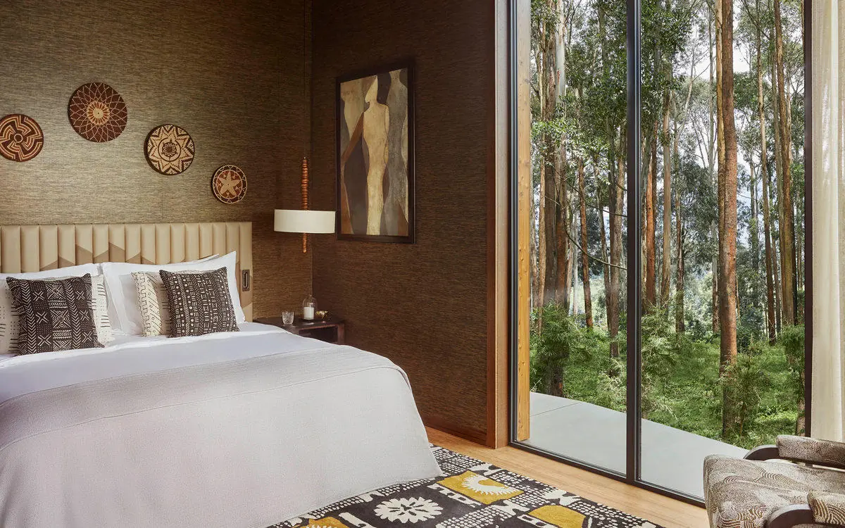 Bedroom with forest view through large windows, Gorilla’s Nest, Volcanoes National Park, Rwanda
