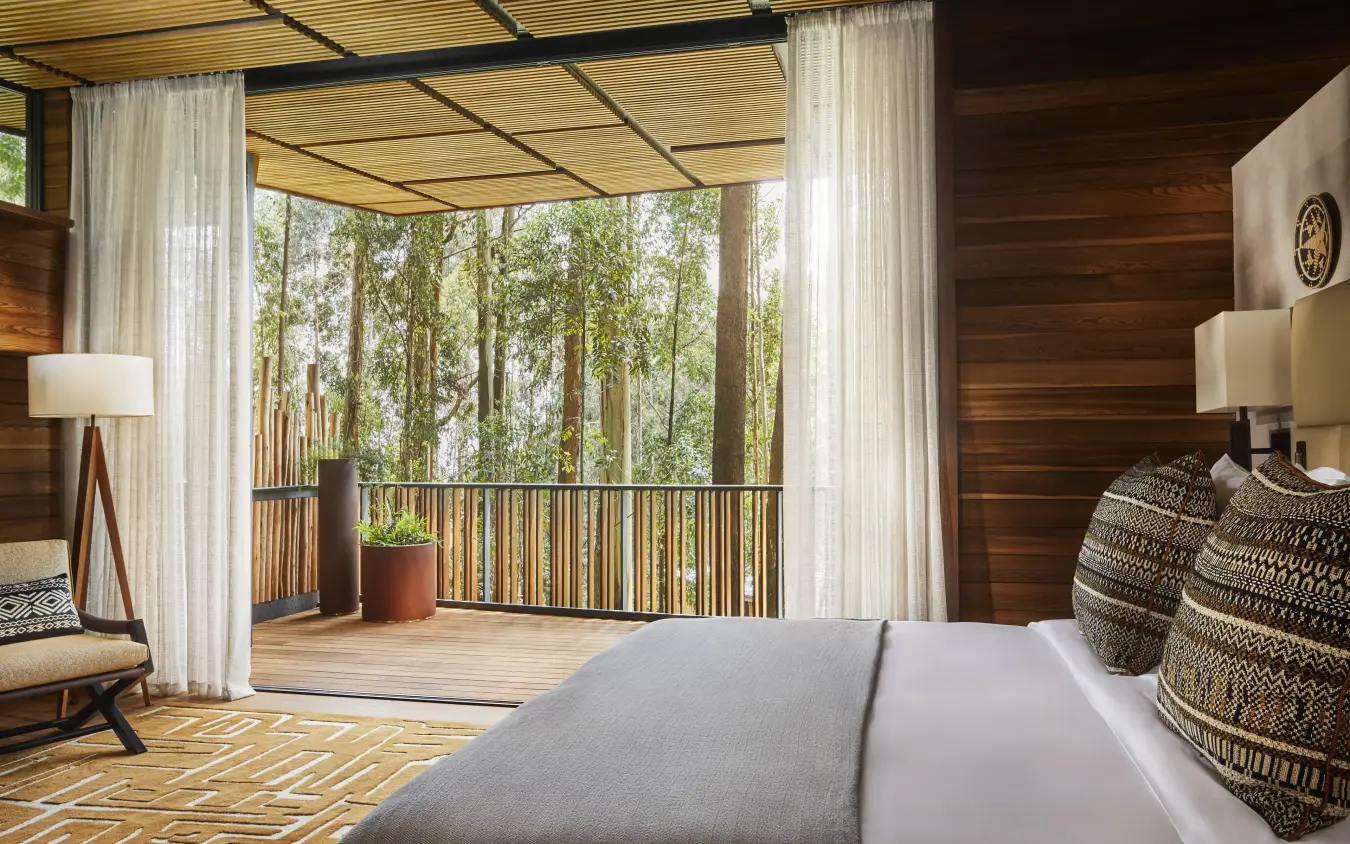 Bedroom with forest view from private deck and curtains, Gorilla’s Nest, Volcanoes National Park, Rwanda