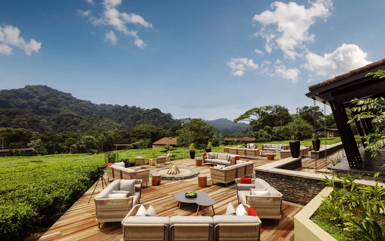 Wooden deck lounge area overlooking green valley and forested hills, Nyungwe House, Nyungwe Forest, Rwanda