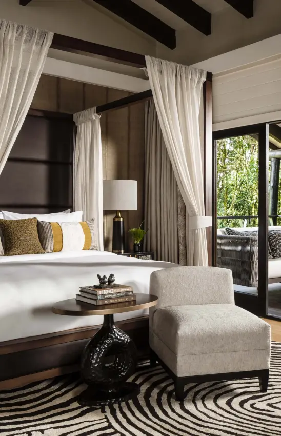 Canopy bed with cream curtains and open deck view, Nyungwe House, Nyungwe Forest, Rwanda