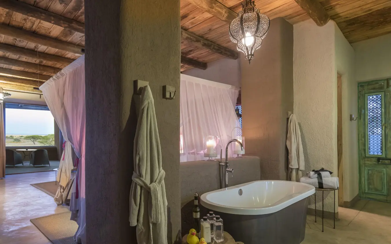 Spacious bathroom with freestanding tub and green doors, Onguma The Fort, Etosha National Park, Namibia