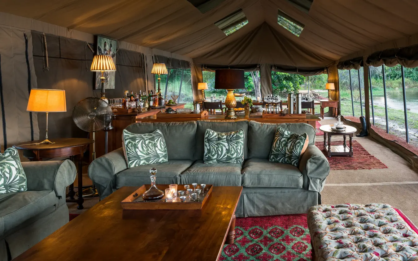 Luxurious safari lodge lounge with gray furnishings and large windows, Papa’s Camp, Murchison Falls NP, Uganda