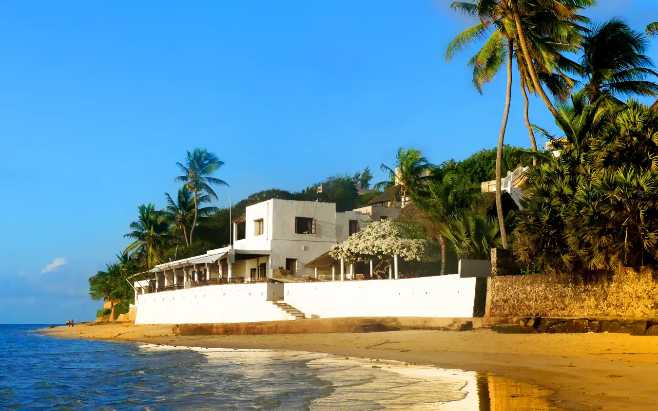 White beachfront building with palm trees and sandy shore, Peponi Hotel, Lamu Archipelago, Kenya