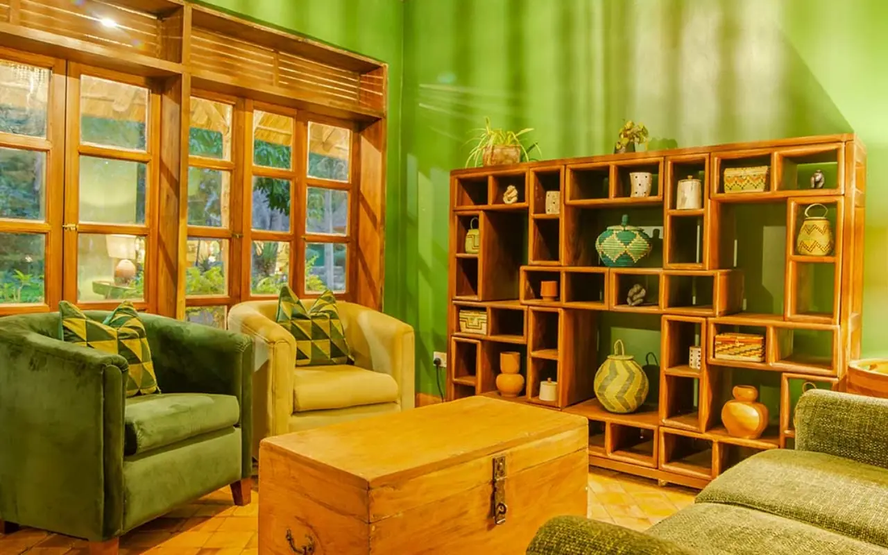 Green lounge with wooden shelving, seating, and large windows, Primate Lodge, Kibale Forest, Uganda