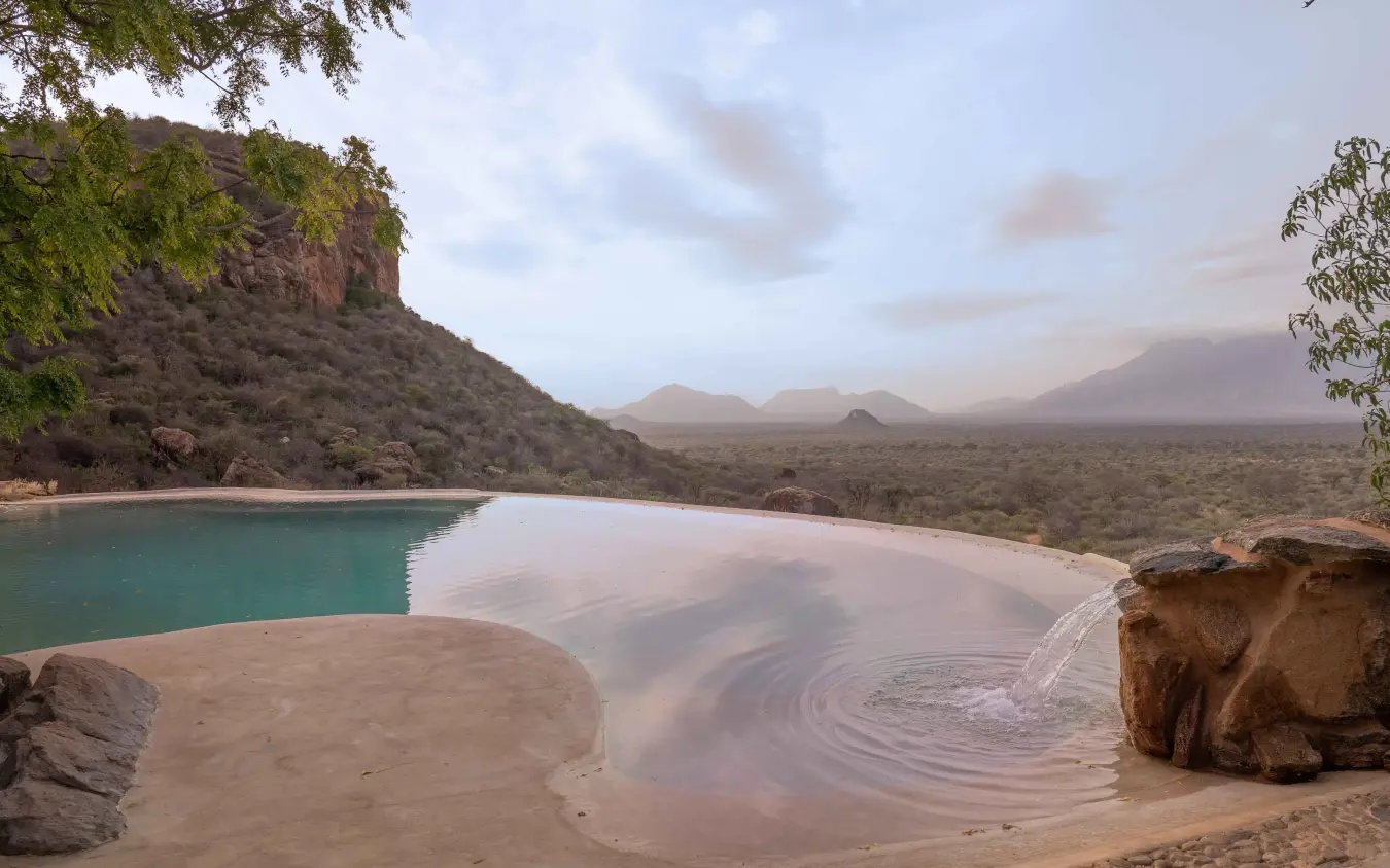 Pristine beach cove with turquoise water and mountain backdrop, Reteti House, Northern Kenya, Kenya