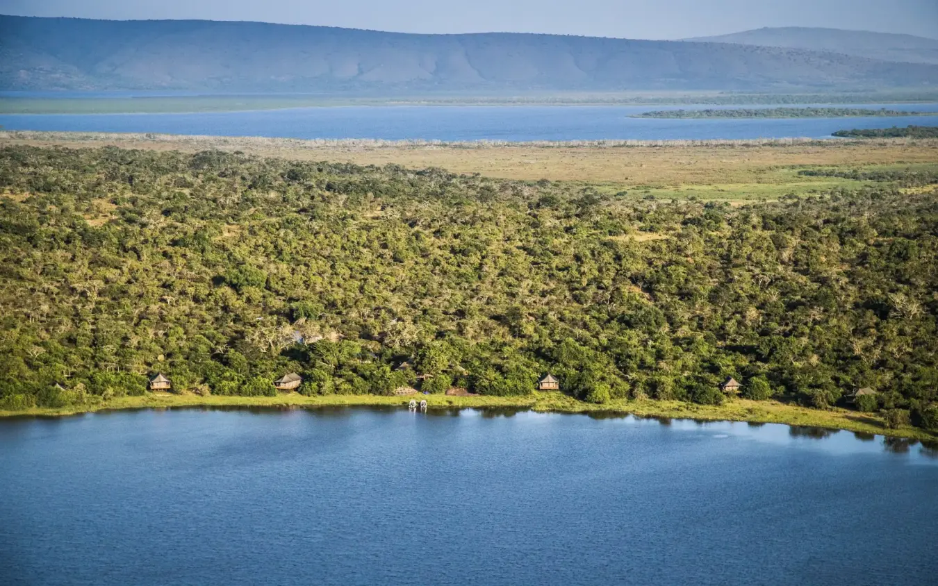Aerial view of lake with forested shoreline and distant mountains, Ruzizi Tented Lodge, Akagera National Park, Rwanda