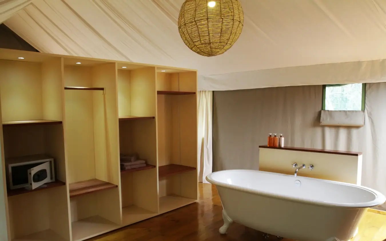 Luxury bathroom with freestanding tub and wooden shelving, Ruzizi Tented Lodge, Akagera National Park, Rwanda