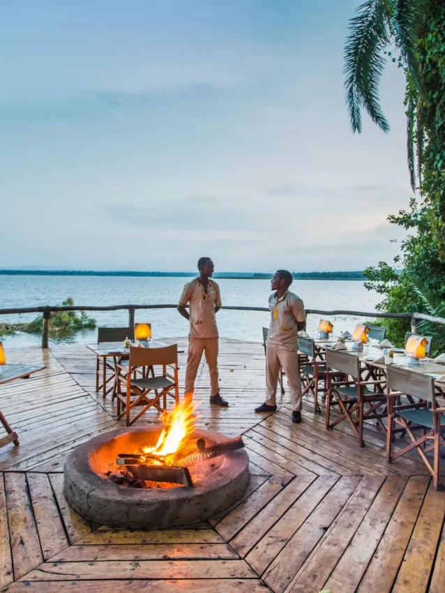 Waterfront deck at dusk with fire pit and seating, Ruzizi Tented Lodge, Akagera National Park, Rwanda