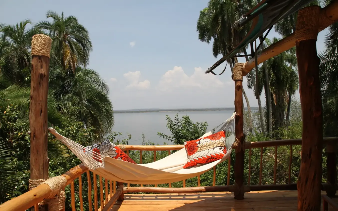 Hammock on wooden deck overlooking calm lake water, Ruzizi Tented Lodge, Akagera National Park, Rwanda