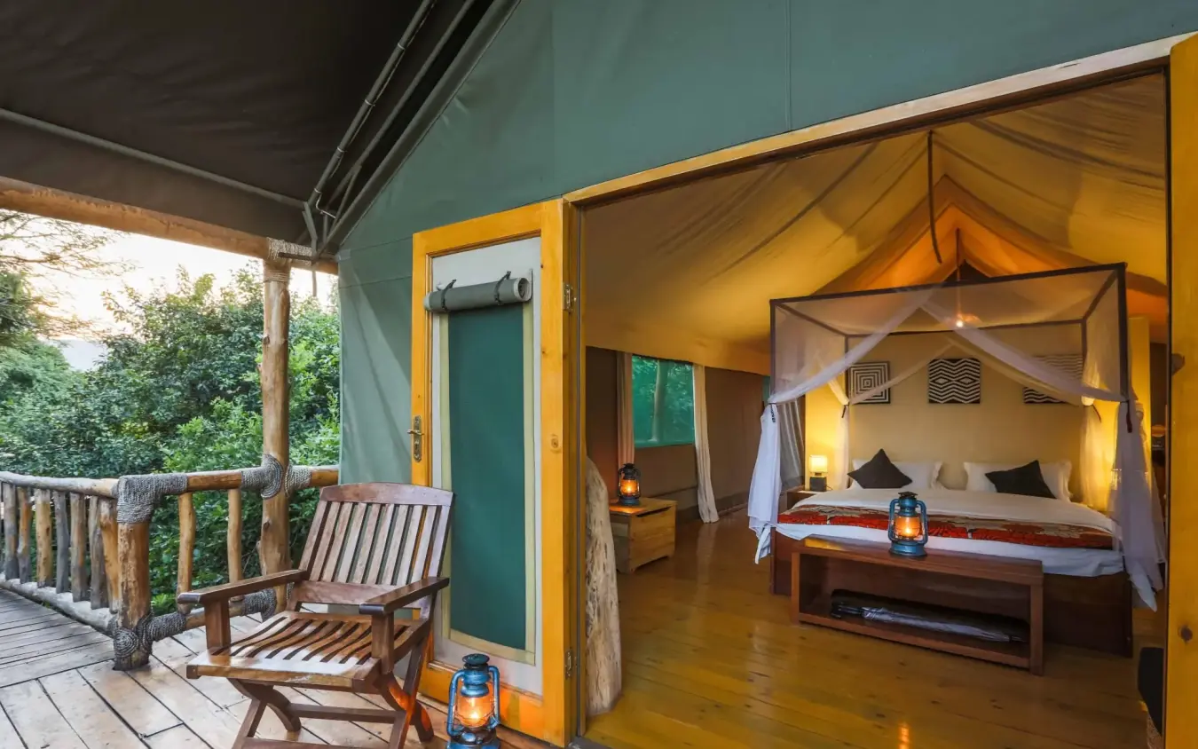 Luxury tent bedroom with canopy bed and deck seating, Ruzizi Tented Lodge, Akagera National Park, Rwanda