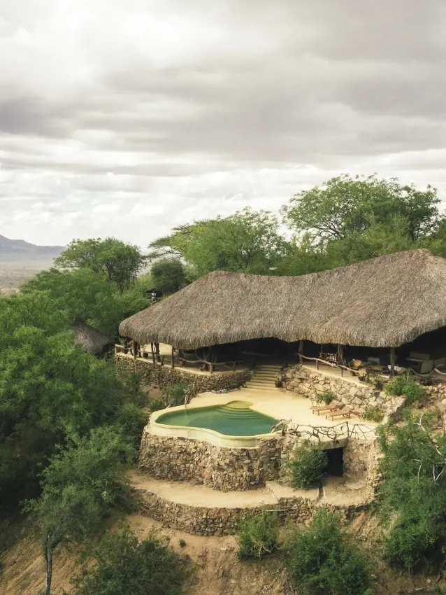 Thatched treehouse lodge perched on rocky outcrop surrounded by acacia trees, Sarara Treehouses, Northern Kenya, Kenya