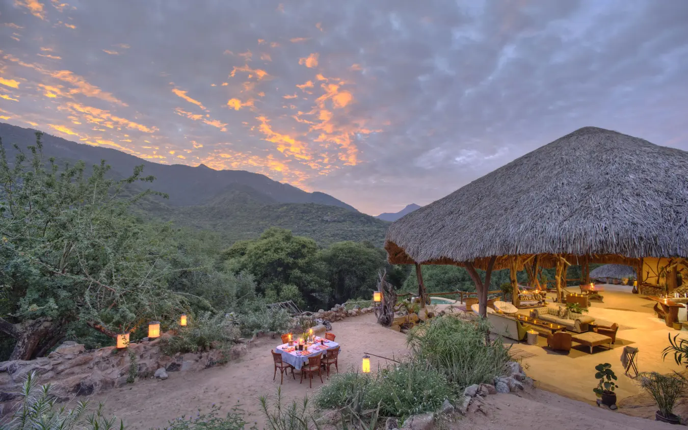 Safari lodge with thatched roof at sunset in mountains, Sarara Treehouses, Northern Kenya, Kenya