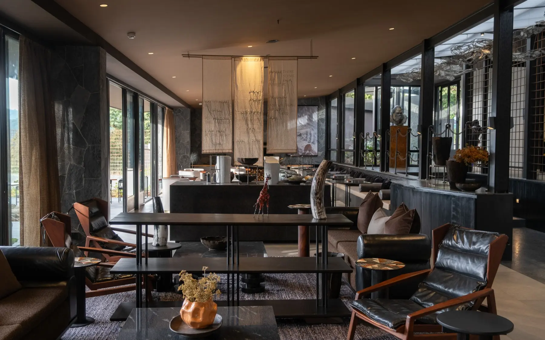 Modern lounge with leather seating and floor-to-ceiling windows, Silverback Lodge, Bwindi Impenetrable Forest, Uganda
