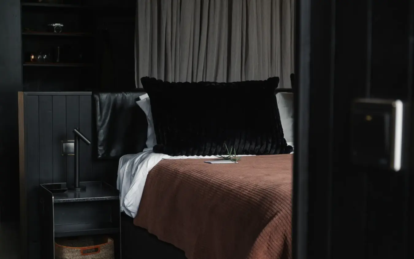 Modern bedroom with black headboard and brown bedding, Silverback Lodge, Bwindi Impenetrable Forest, Uganda
