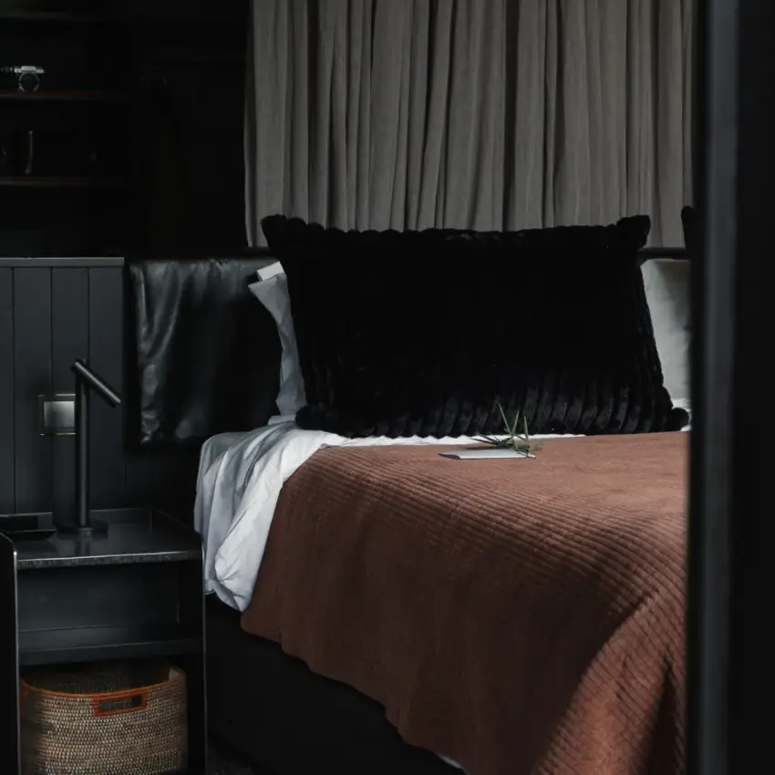 Modern bedroom with black headboard and brown bedding, Silverback Lodge, Bwindi Impenetrable Forest, Uganda