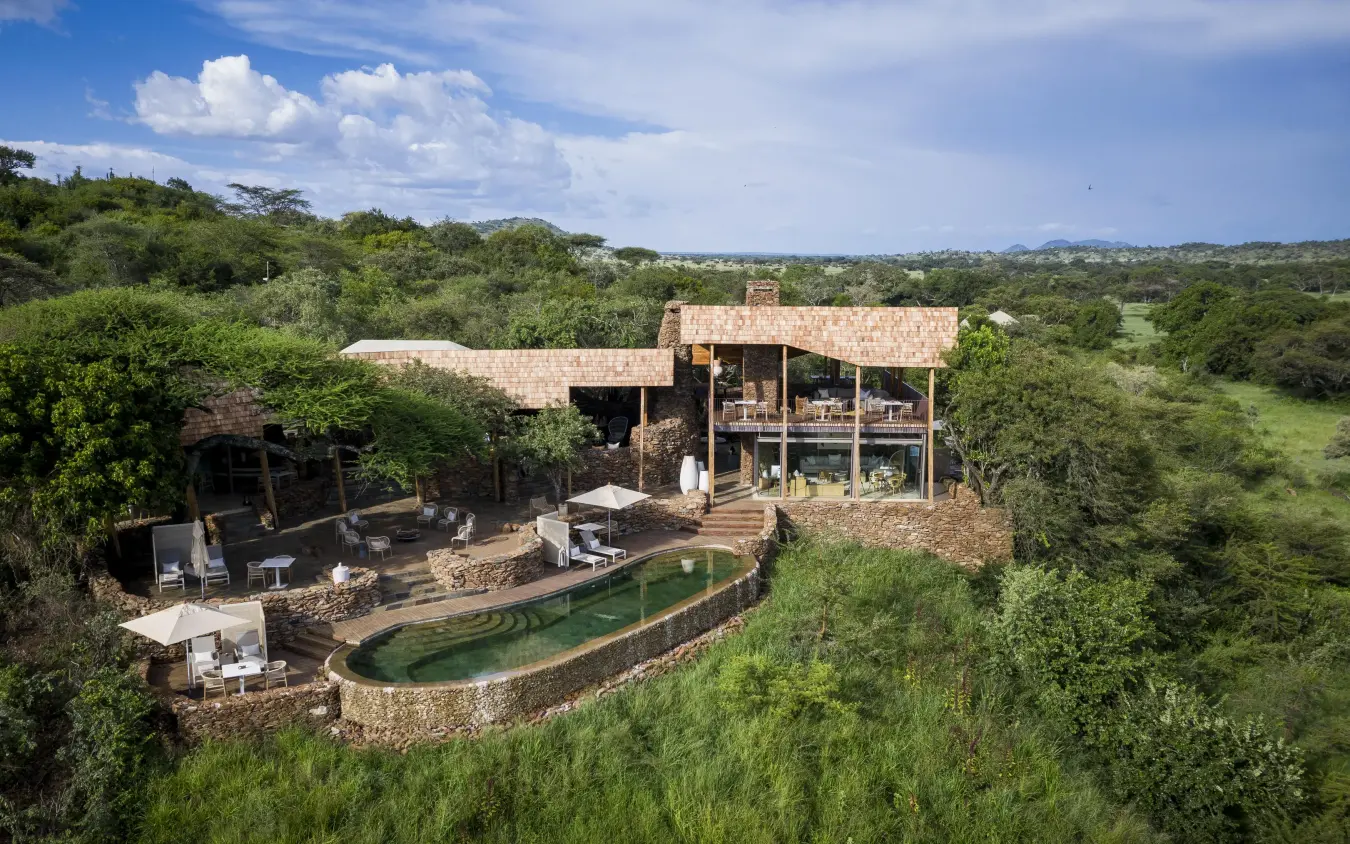 Modern lodge building with pool surrounded by savanna vegetation, Singita Faru Faru Lodge, Serengeti National Park, Tanzania