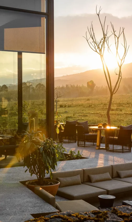 Modern lodge terrace overlooking valley at golden hour, Singita Kwitonda Lodge, Volcanoes National Park, Rwanda